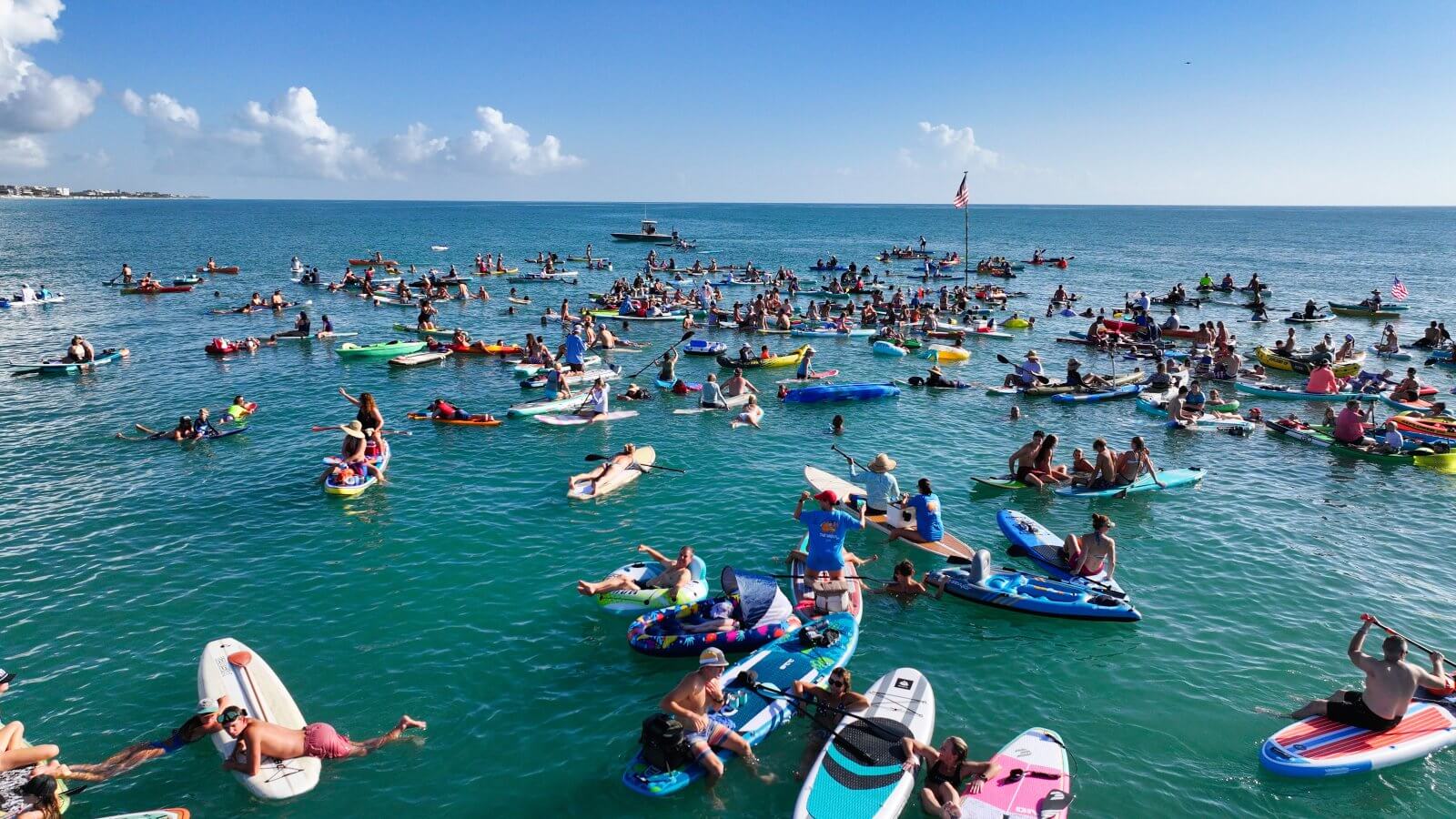 People on paddleboards and kayaks at the swim to the wreck fourth of July event