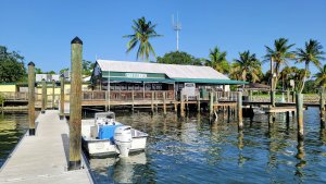 The Riverside view of Riverside Cafe. With a boat docked and tables and chairs along riverside cafes deck.