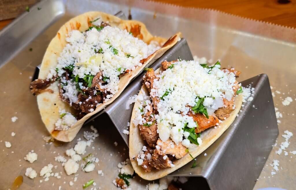 3 Bite Tacos (Tex-Mex Style) – Brisket (left) and grilled chicken (right) tacos served on your choice of tortilla, topped with onions, cilantro, and queso fresco. Foodie Tip: The brisket taco also has griddled cheese on the inside of the tortilla, adding an additional layer of cheesy flavor.
