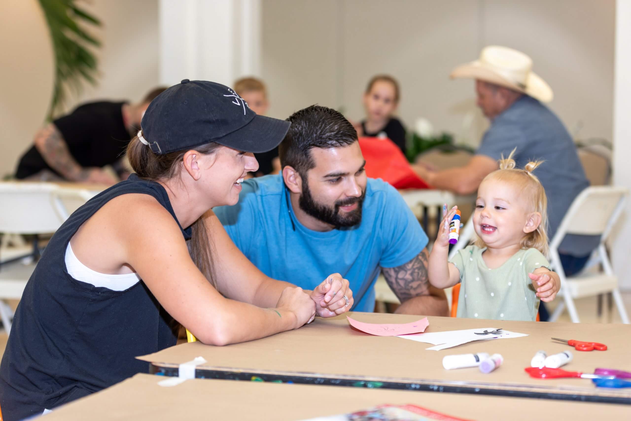 A family smiling while crafting at the Vero Beach Museum of Arts Children Festival.