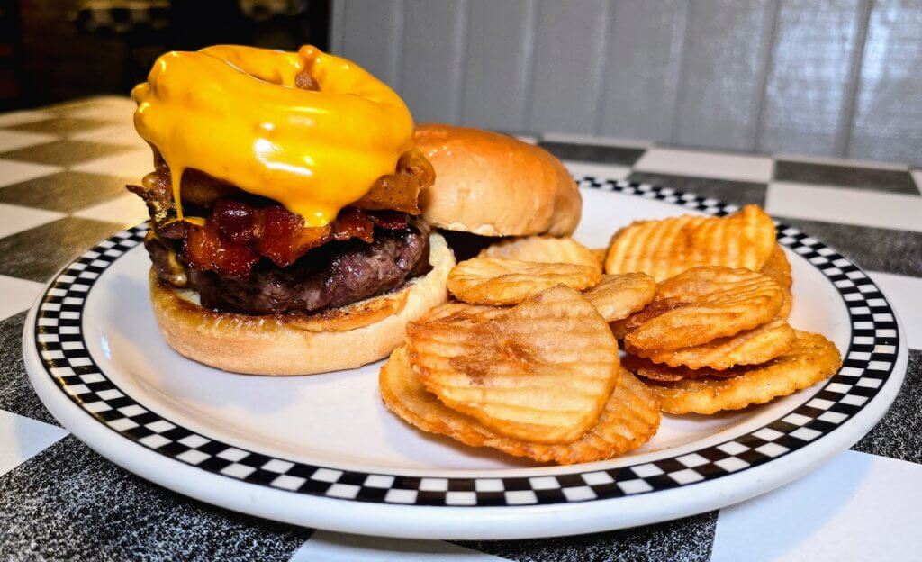 Mrs Macs cheesy TrailBlazer angus beef burger topped with bacon, freshly melted cheese and bbq sauce.