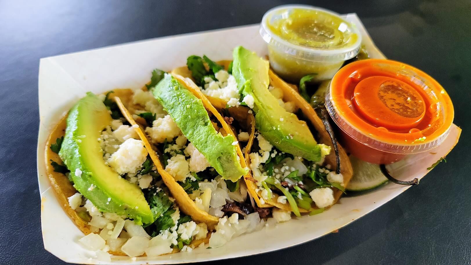 Traditional tacos with your choice of protein on corn tortillas, topped with onions, cilantro, cotija cheese, and avocado slices.