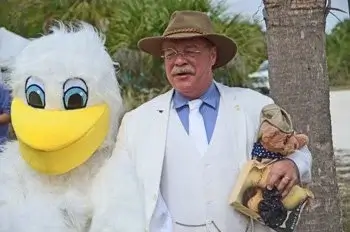 A man standing next to a large pelican at the Pelican Island National Wildlife Refuge anniversary festival. 