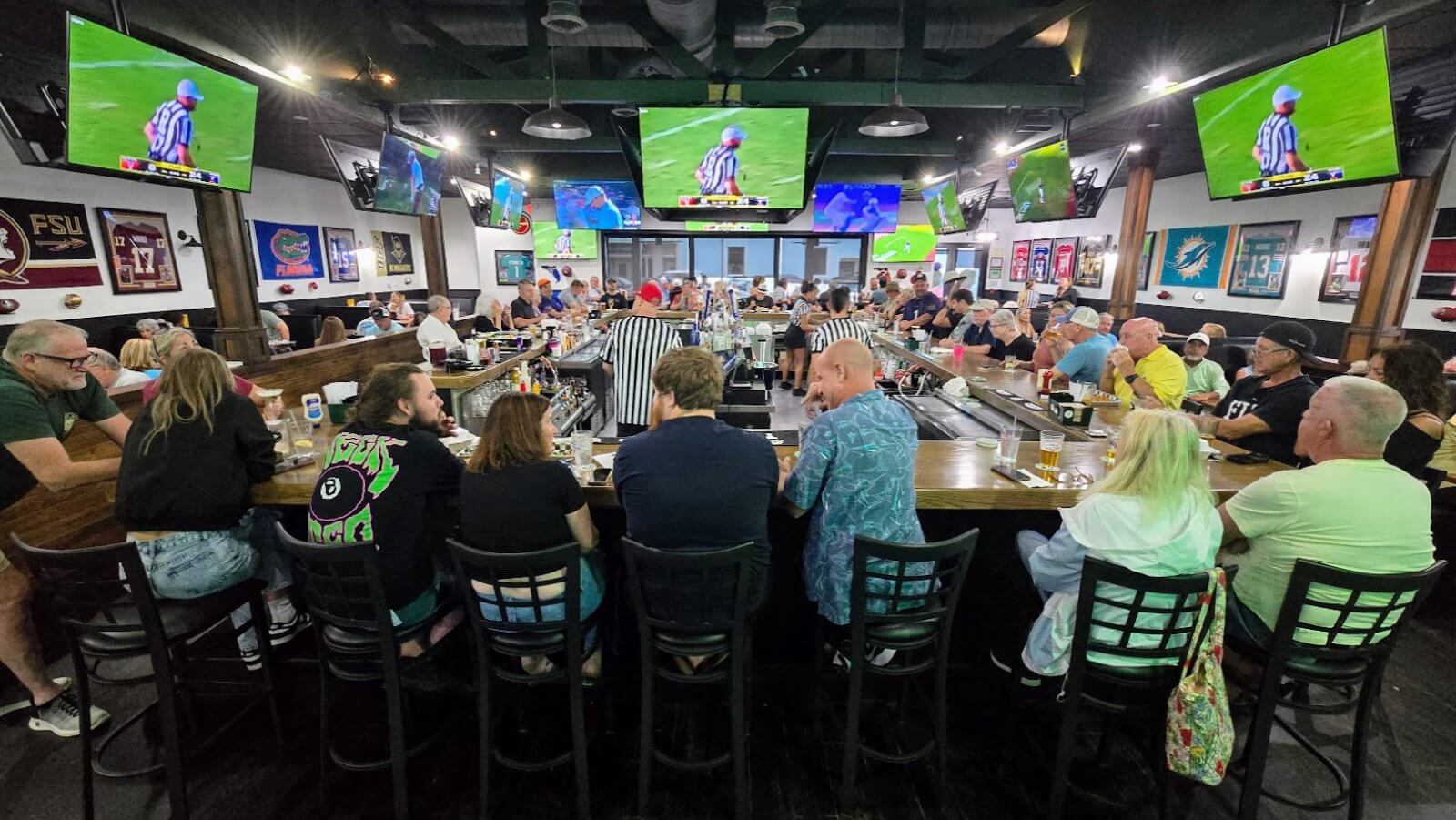 People sitting at the bar watching sports at the new Vero Sports Bar