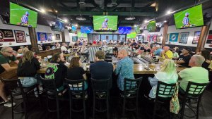 People sitting at the bar watching sports at the new Vero Sports Bar