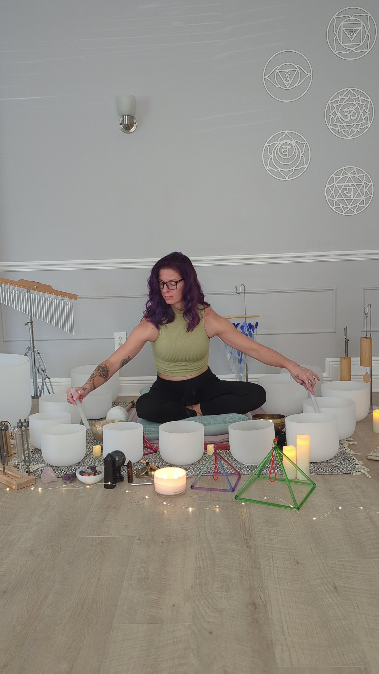 A woman with purple hair plays singing bowls during a sound healing session in Vero Beach, FL