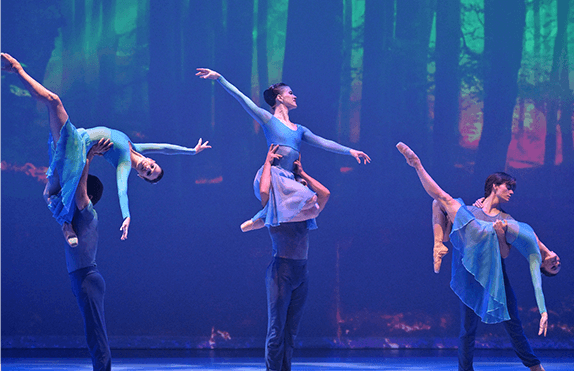 3 male ballerinas holding up 3 female ballerinas in 3 different poses and heights at the riverside dance festival with ballet vero beach. 